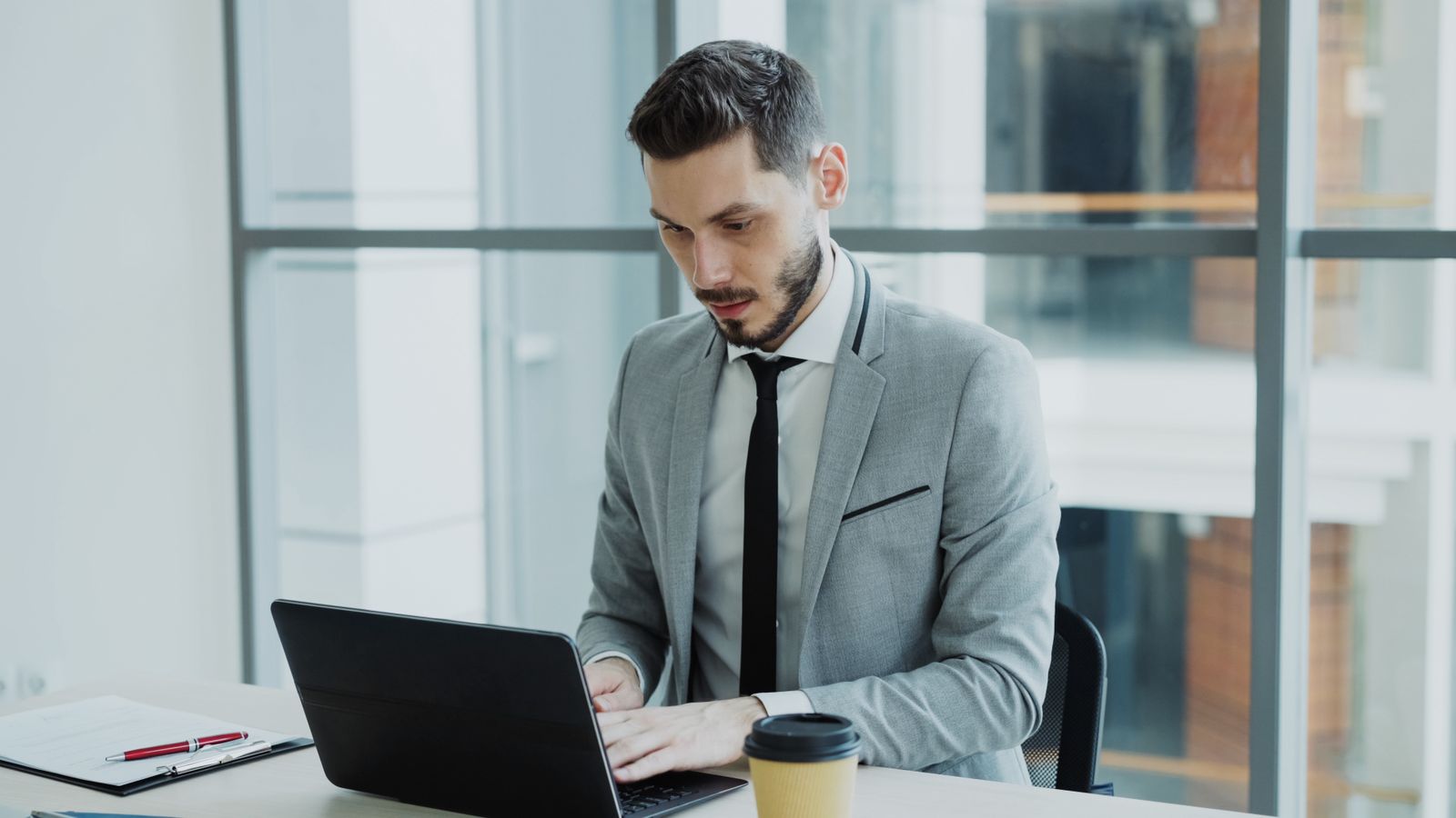 An owner-operator working at a laptop, running MariaDB and the business without a dedicated DBA
